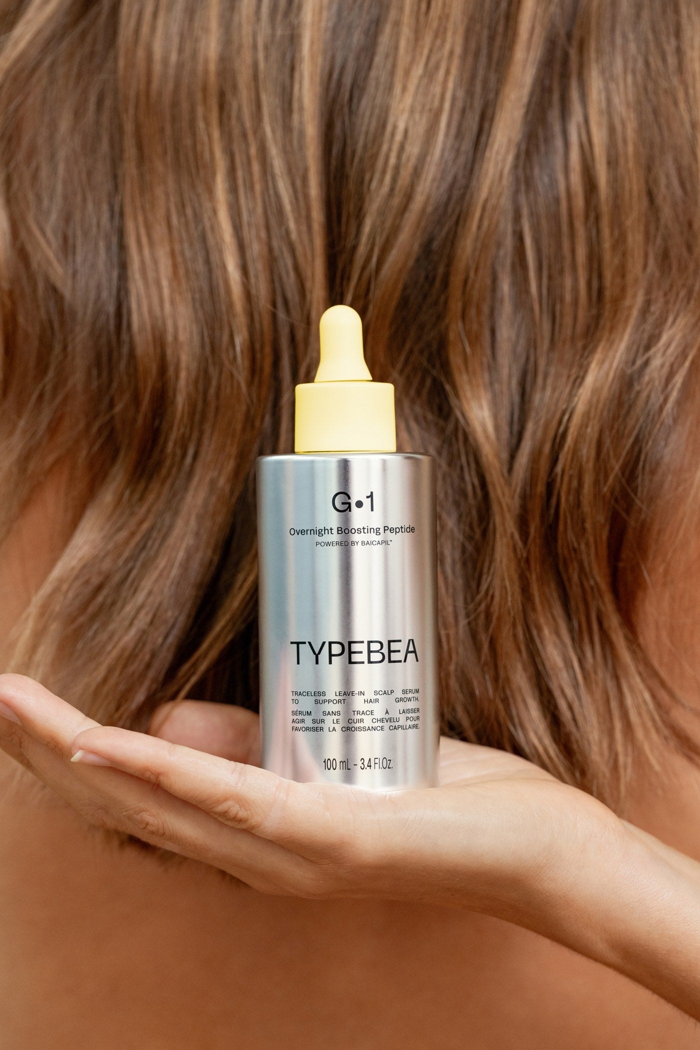 Model holding G&middot;1 against her hair